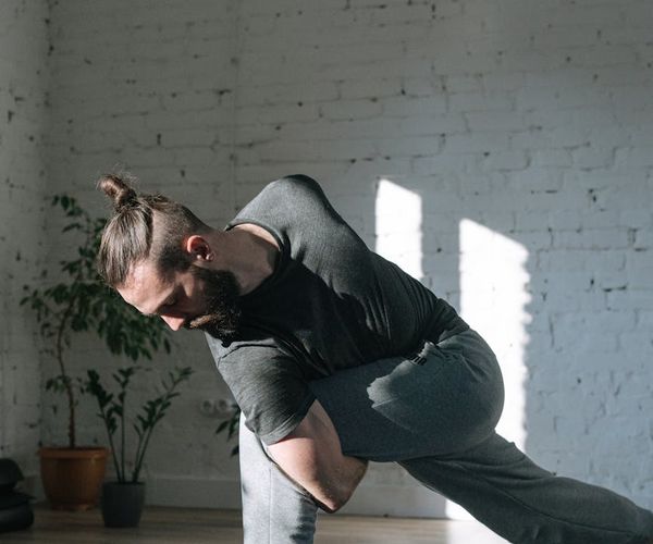Man doing focus meditation after physical activity in grey room
